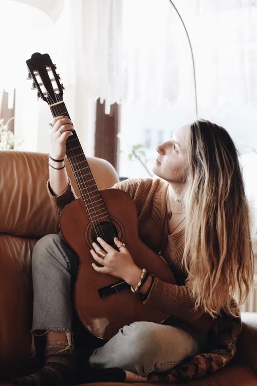 Left handed girl playing a left handed acoustic guitar